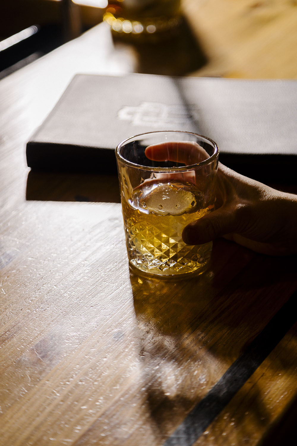 Olde Raleigh Bourbon in a glass sitting in front of a menu