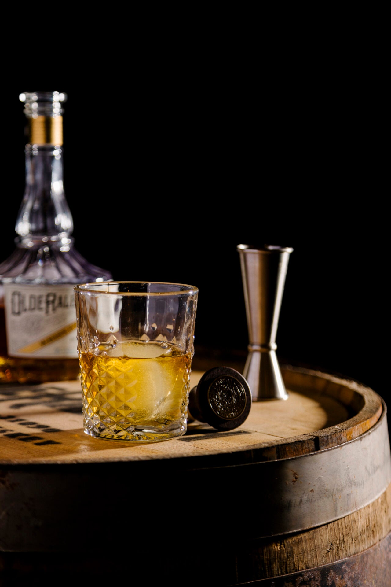 olde raleigh bourbon in a glass on a barrel