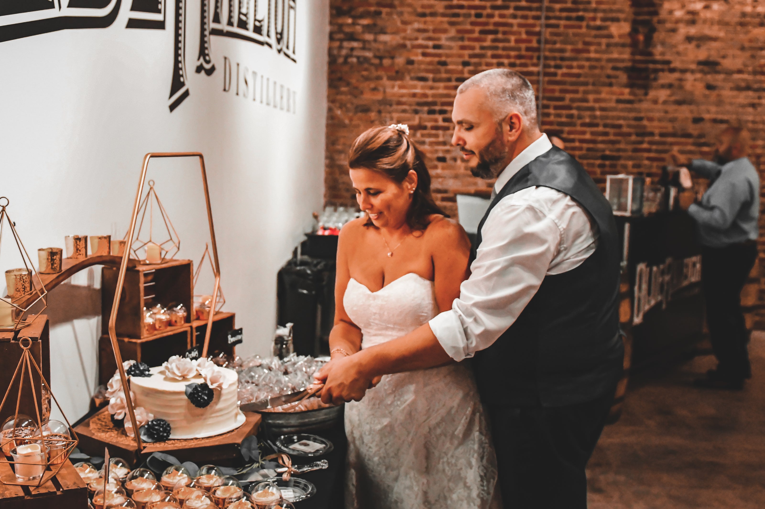 bride and groom cutting their cake at olde raleigh distillery