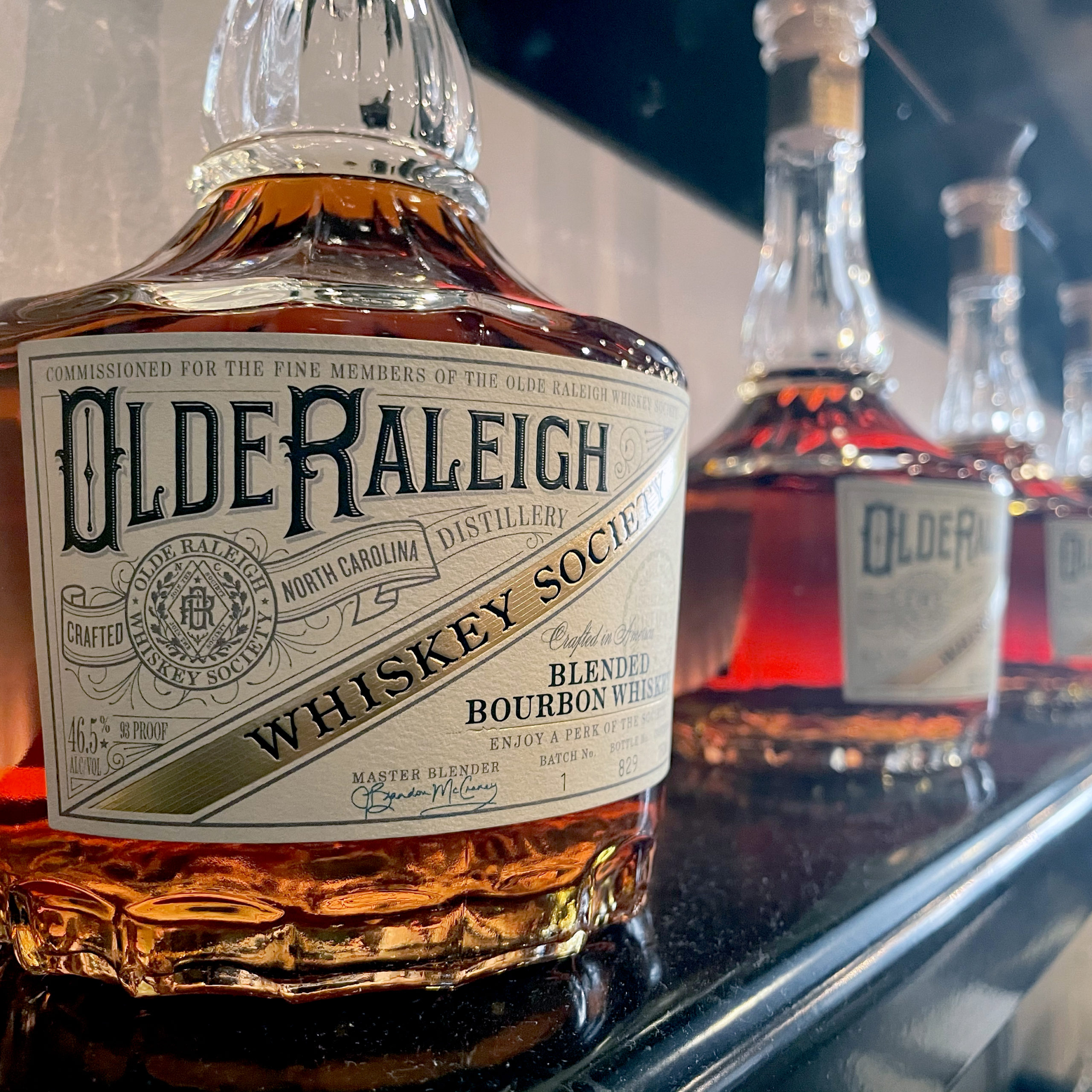 Olde Raleigh Whiskey Society bottles in a line