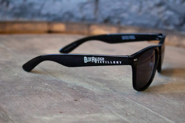 black sunglasses with olde raleigh distillery logo